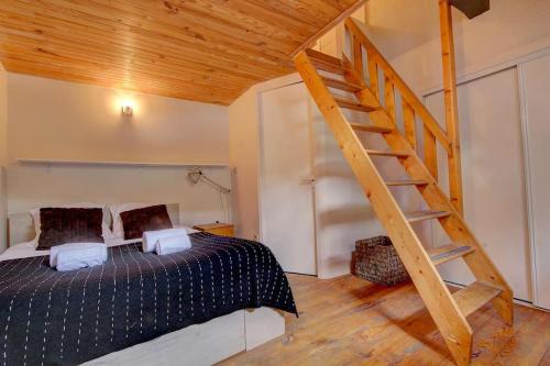 ein Schlafzimmer mit einem Bett und einer Holztreppe in der Unterkunft Iris Triplex studio in Chamonix-Mont-Blanc