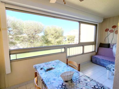 une pièce avec une table et une grande fenêtre dans l'établissement Appartement T3 - Parking - Piscine, Tennis, Proche Plages et Commerces - Six-Fours-les-Plages - FR-1-316-50, à Six-Fours-les-Plages