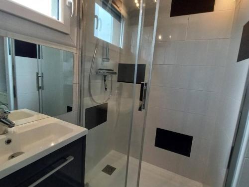 uma casa de banho com um chuveiro e um lavatório. em Appartement Marseillan-Plage, 2 pièces, 6 personnes - FR-1-387-48 em Marseillan