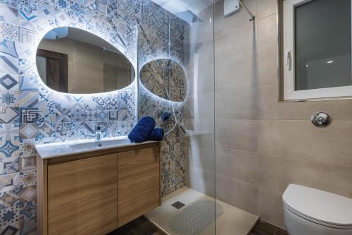 a bathroom with a toilet and a sink and a mirror at Sandstone A8 Marsascala - 15minute drive to Valletta in Marsaskala