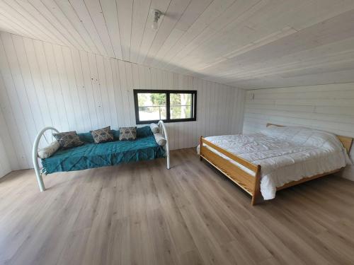 ein Schlafzimmer mit einem Bett in der Mitte eines Zimmers in der Unterkunft JOLIE MAISON BOIS 8 à 10 personnes in Saint-Jean-de-Monts