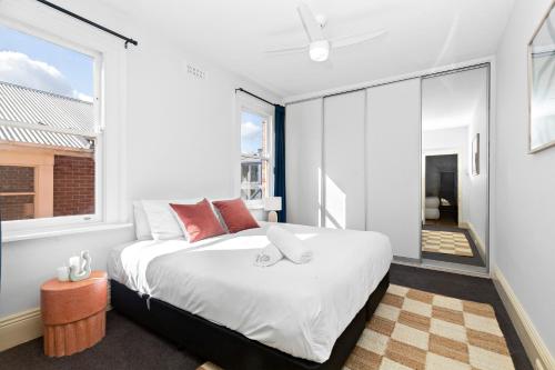 een slaapkamer met een groot bed en een groot raam bij The White House Fitzroy - One of the largest single dwelling accommodations in Melbourne