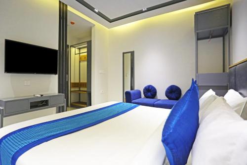 新德里的住宿－Applewood Residency - Free Airport transffer，一间卧室配有一张大床和一台平面电视