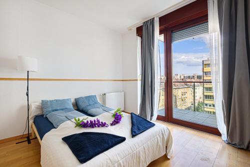 ein Schlafzimmer mit einem Bett mit lila Blumen darauf in der Unterkunft High Class Residence Leopold in Budapest