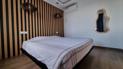 a bedroom with a bed and a guitar on the wall at Signal Appartments in Abidjan