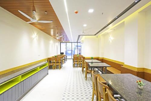 uma sala de jantar com mesas e cadeiras em Applewood Residency - Free Airport transffer em Nova Deli