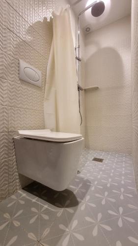 a bathroom with a white toilet and a shower at Signal Appartments in Abidjan