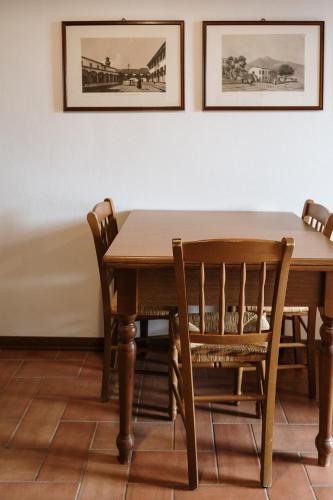 a dining room table with chairs and pictures on the wall at Villa Nottola in Montepulciano