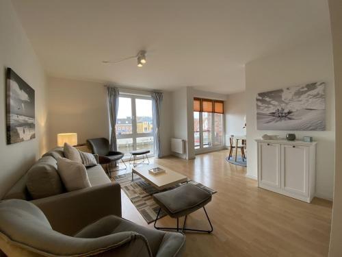 胡蘇姆的住宿－Simmerdeis am Hafen，客厅配有沙发和桌子