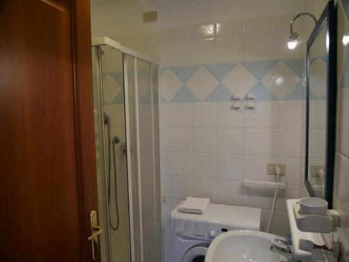 een badkamer met een douche, een toilet en een wastafel bij Lounge Del Duca, centralissimo bicamere su due livelli - posto auto a richesta in Grado