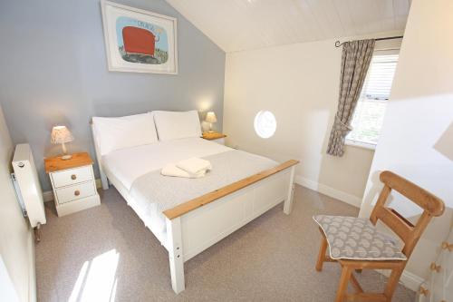 um pequeno quarto com uma cama e uma cadeira em Thirsk Stays - Bakery Cottage em Thirsk