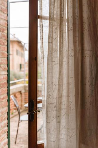 a glass door with a curtain on a window at Villa Nottola in Montepulciano
