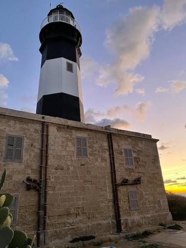 a lighthouse sitting on top of a brick building at Sunrise Apt - Modern Studio Apt near the Beach in Birżebbuġa