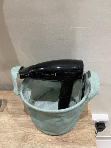a black hair dryer in a bowl on a table at Sunrise Apt - Modern Studio Apt near the Beach in Birżebbuġa