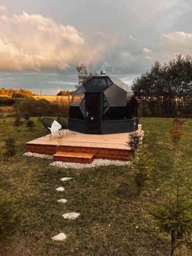 a black tent on a wooden deck in a field at Kuuselepa klaaskuppel in Tartu
