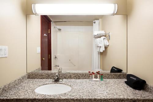 艾德森的住宿－埃德森華美達酒店，一间带水槽和大镜子的浴室