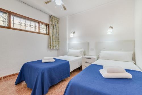 2 camas en una habitación con sábanas azules en Apartamentos Don Quijote, en Playa del Inglés
