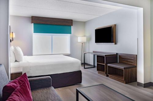 a hotel room with a bed and a tv at Wingate by Wyndham Atlanta-Duluth in Duluth
