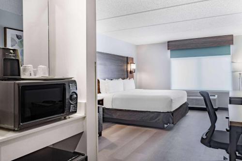 a hotel room with a bed and a tv at Wingate by Wyndham Atlanta-Duluth in Duluth