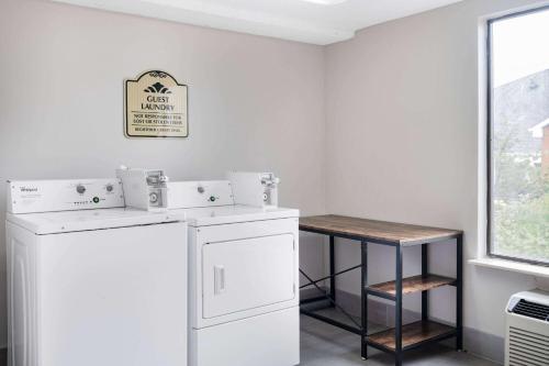 - une buanderie avec un lave-linge, un sèche-linge et une table dans l'établissement Wingate by Wyndham Atlanta-Duluth, à Duluth