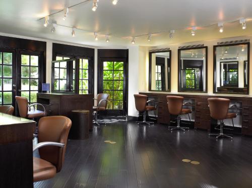 a large room with chairs and tables and windows at The Brazilian Court Hotel in Palm Beach