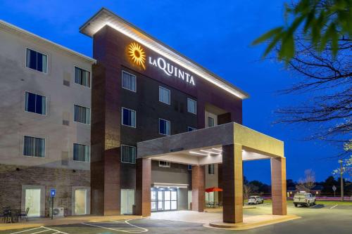 un hotel con un cartel en la parte delantera en La Quinta Inn & Suites by Wyndham Augusta Fort Eisenhower, en Augusta