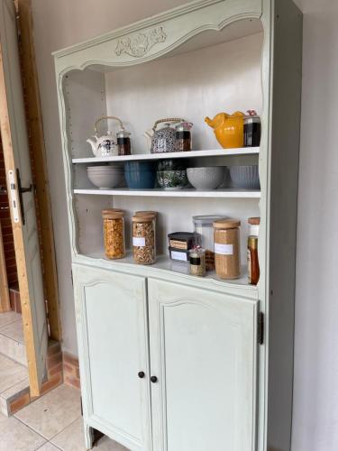 une armoire blanche contenant des produits alimentaires dans l'établissement 32 parc des sports chez catherve, à Saint-Médard-de-Guizières