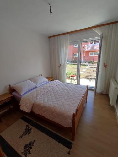 a bedroom with a bed and a sliding glass door at Apartman Bor s velikom terasom idealan za boravak s obitelji in Livno