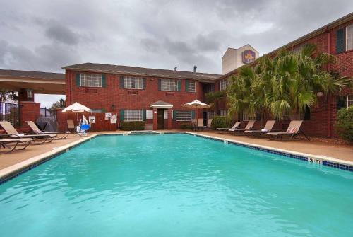a large swimming pool in front of a building at Baymont by Wyndham Houston/Westchase in Houston