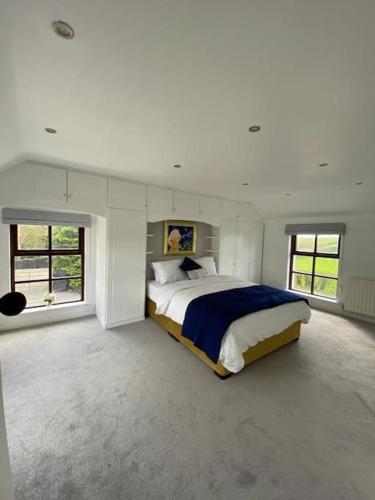 a large white bedroom with a large bed in it at Broughanore Lodge in Dunloy
