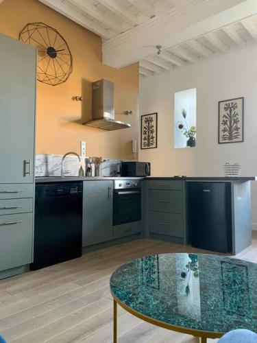 - une cuisine avec une table en verre dans une pièce dans l'établissement Appartement rénové de caractère, à Saint-Rémy-de-Provence