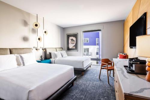 a hotel room with two beds and a desk at The Shay, a Destination by Hyatt in Los Angeles