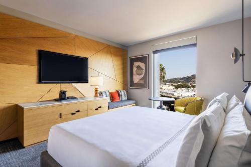 a hotel room with a bed and a flat screen tv at The Shay, a Destination by Hyatt in Los Angeles