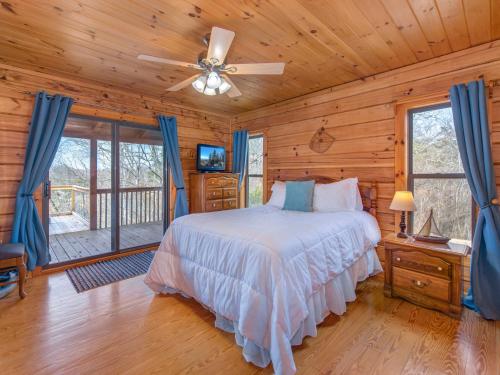 1 dormitorio con 1 cama y ventilador de techo en Stillwater Cove, en Dandridge