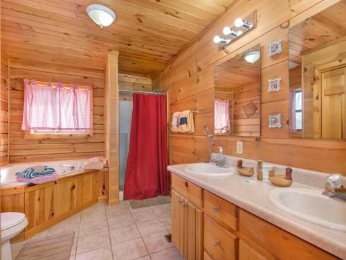 baño con 2 lavabos y ducha en una cabaña de madera en Stillwater Cove, en Dandridge