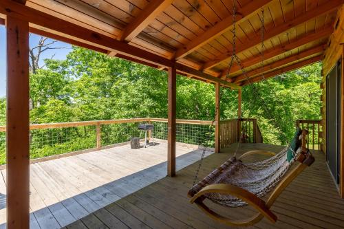 a hammock on a porch with a view of the woods at Stillwater Cove in Dandridge