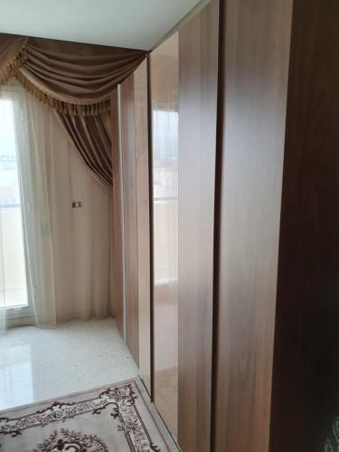 a mirrored closet in a room with a window at Appartement confortable - Sfax centre in Sfax