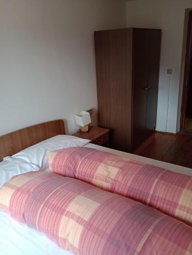 a bedroom with a bed with a striped blanket on it at Sasso Nero in Chiesa in Valmalenco