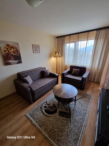 a living room with a couch and a table at Suite Roma 2 at Spa Club Bor in Velingrad