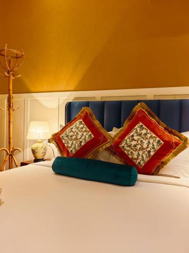 a bed with red pillows and a blue head board at Hotel Penaga in George Town