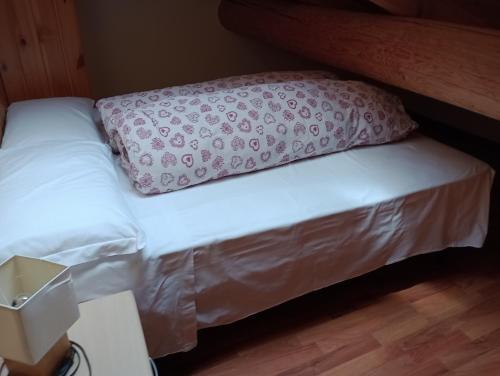 a bed in a room with a pillow on it at Sasso Nero in Chiesa in Valmalenco