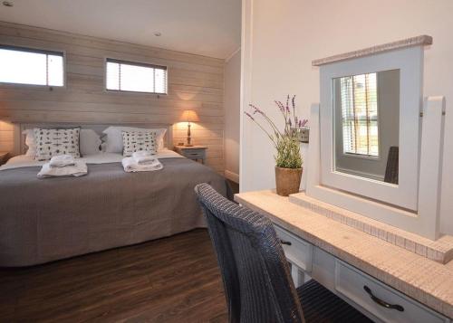 a bedroom with a bed and a table with a mirror at Cherry Bird Country Park in Newbury