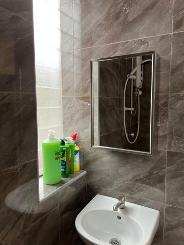 y baño con lavabo, ducha y espejo. en The Neighbour KKB - Rooms with shared bathroom, en Kuala Kubu Baharu