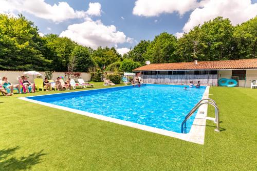 une grande piscine avec des personnes assises autour de celle-ci dans l'établissement Camping Bois de St Hilaire, à Chalandray