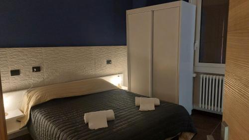 a bedroom with a bed with two towels on it at Hotel La Torre in Formigine