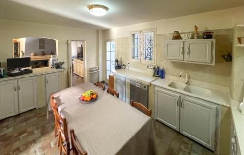 une cuisine avec une table avec un bol de fruits dessus dans l'établissement Lovely Home In La Roque-Sur-Pernes, à La Roque-sur-Pernes
