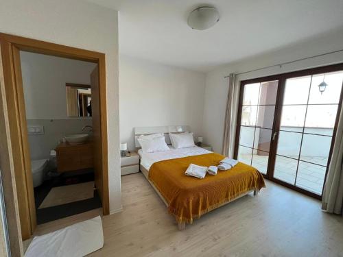 a bedroom with a bed and a large window at Kalaja Apartment in Prizren