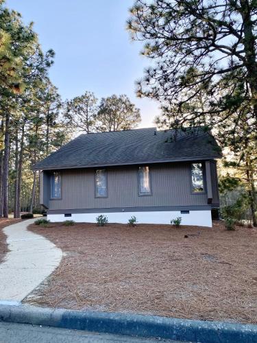 a gray house with a gambrel roof at Golf Front SFH, 3 BR, 2 BA, 4 beds, sleep 6 on Pinehurst #6 in Pinehurst