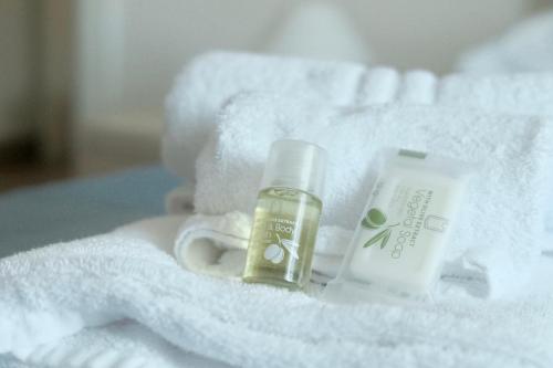 uma pilha de toalhas com um frasco de hidratantes e um frasco de sabonete em Casa Pierina em Santa Marinella