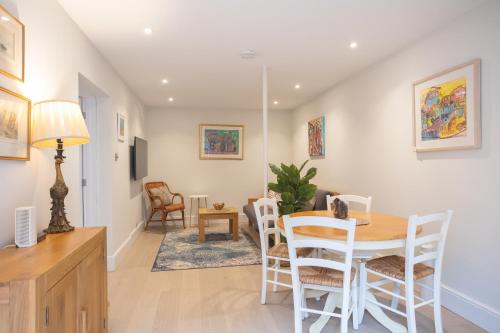uma sala de jantar e sala de estar com mesa e cadeiras em Spacious 1BR Victorian Cheltenham flat in Cotswolds Sleeps 4 - FREE Parking em Cheltenham